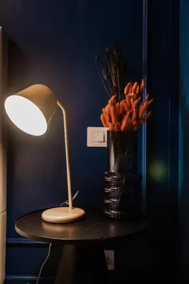 a table with a lamp and a vase of flowers at Telesio Suite in Rome