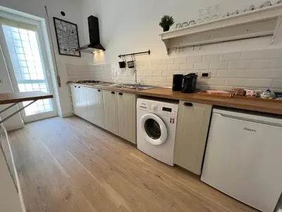 a kitchen with a washing machine and a sink at Appartamento Millelire in Rome