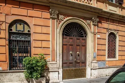 a building with a wooden door and two windows at Porta Castello Suites in Rome