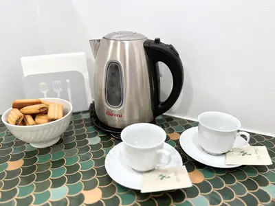a coffee pot and two cups and a bowl of cookies at Casa Lovera in Vaticano in Rome