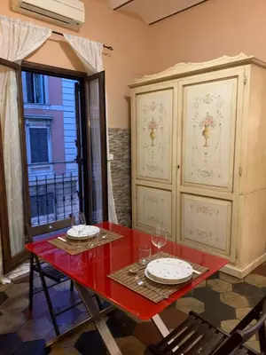 a dining room with a red table and a cabinet at Termini GHome in Rome