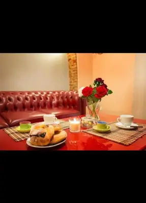 a table with a plate of food and a vase with roses at Termini GHome in Rome