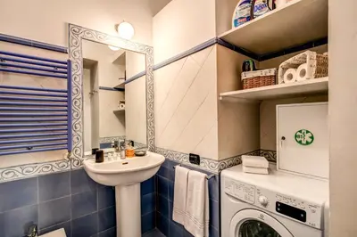 a bathroom with a sink and a washing machine at Domus Lunae in Rome