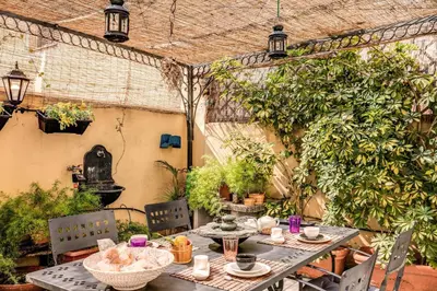an outdoor patio with a table and chairs at Domus Lunae in Rome