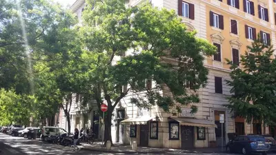 a building on a city street with trees and cars at Domus Lunae in Rome