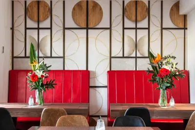 two tables with flowers in vases on them in a restaurant at Fragrance Hotel St. Peter in Rome
