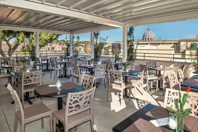 a restaurant with tables and chairs on a patio at Fragrance Hotel St. Peter in Rome