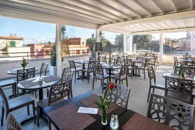 a restaurant with tables and chairs on a patio at Fragrance Hotel St. Peter in Rome