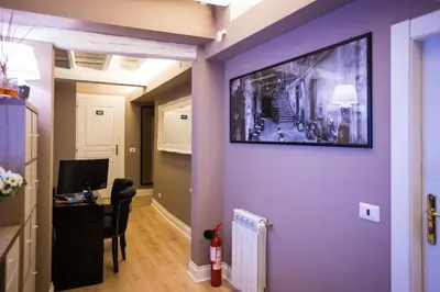 a living room with a purple wall with a tv on it at Minerva Relais in Rome