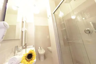 a bathroom with a toilet and a sink with a sunflower on it at Windows on Rome in Rome