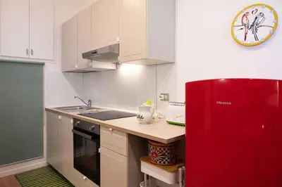 a kitchen with a red refrigerator and a sink at Casa Bouganville - St. Peter Romantic Apartment in Rome