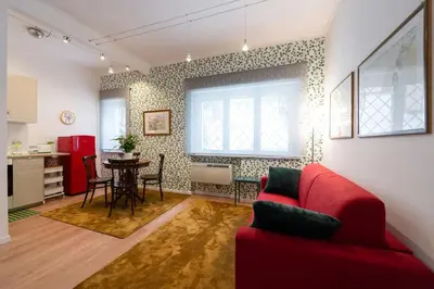 a living room with a red couch and a table at Casa Bouganville - St. Peter Romantic Apartment in Rome