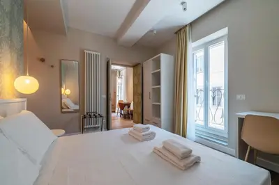 a bedroom with a white bed with towels on it at Luxury Corso Suite - DesignD Stays in Rome