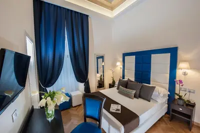 a bedroom with a large bed with blue curtains at DVE Suite Rome in Rome