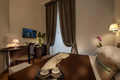 a hotel room with a bed and a desk at DVE Suite Rome in Rome