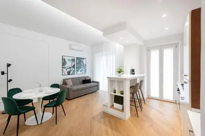 a living room with a table and chairs and a couch at White flat Gallia in Rome