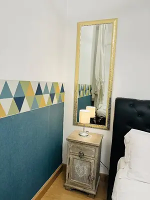 a bedroom with a mirror and a table with a lamp at Bencò House in Rome
