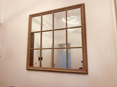 a mirror on a white wall with a window at Bencò House in Rome