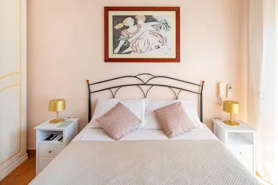 a bedroom with a white bed with two tables and two lamps at Casa Angelina con 3 camere da letto in Rome