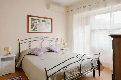 a bedroom with a bed with purple pillows and a window at Casa Angelina con 3 camere da letto in Rome
