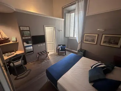a bedroom with a large bed and a desk at NEW! BELLISSIMO PalazzoFranchi Pantheon in Rome