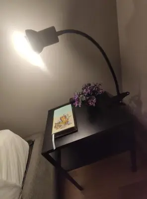 a table with a lamp and a picture and flowers on it at 150 m dal Colosseo - Appartamento Minerva in Rome