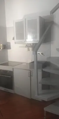 a kitchen with white cabinets and a spiral staircase at Vatican near Sweet Home Terrace in Rome