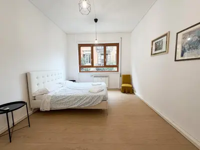 a white bedroom with a bed and a window at Mazzini Boutique Apartment in Rome