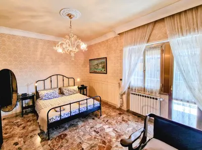 a bedroom with a bed and a chandelier at Grazia Guesthouse in Rome
