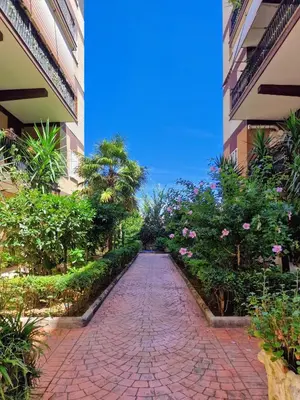 a brick walkway between two buildings with flowering plants at Grazia Guesthouse in Rome