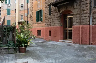 a pink building with purple flowers in a garden at Apartment in front of Vatican Museums and Vatican area - myDen in Rome in Rome