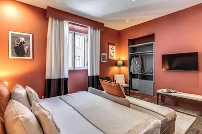 a bedroom with orange walls and a bed and a television at Telier Tomacelli in Rome