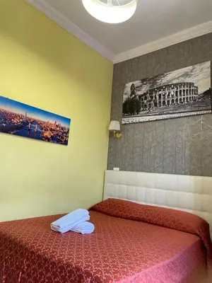 a bedroom with a bed with a red comforter at Mille Guest HOUSE in Rome