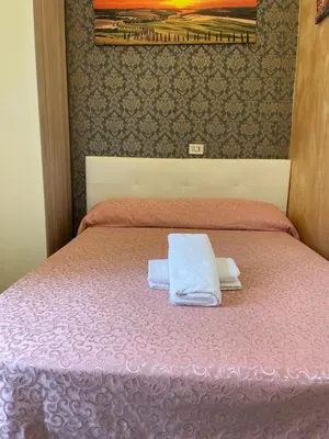 a pink bed with two towels on top of it at Mille Guest HOUSE in Rome