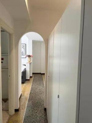 a hallway with an archway in a room with a bedroom at House of Mia in Prati in Rome