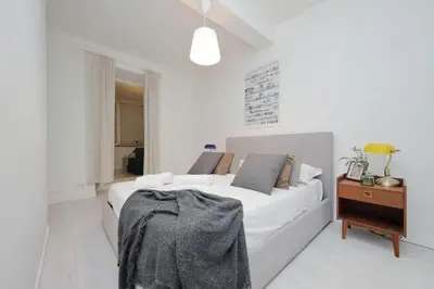 a white bedroom with a white couch and a table at Monti Spacious Apartment 2 in Rome