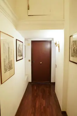a hallway with a brown door and a wooden floor at babuino terrace in Rome