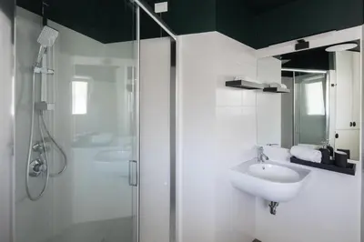 a white bathroom with a sink and a shower at Loft 36 by Nosdom Properties in Rome