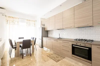 a kitchen with wooden cabinets and a table with chairs at Jmartins Vatican 2 in Rome