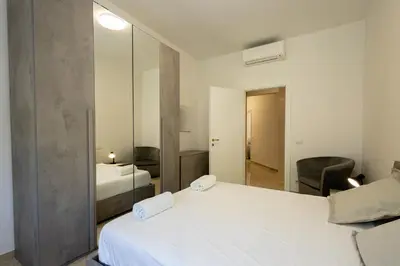a bedroom with two white beds and a mirror at Jmartins Vatican 2 in Rome