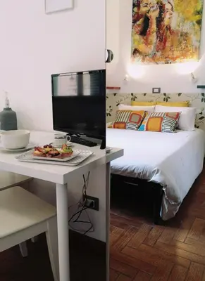 a bedroom with a bed and a desk with a tv at House Villa Fiorelli in Rome