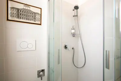 a shower with a glass door in a bathroom at Refined upper-level apartment - Unique View of Rome's Skyline Tibernestrome in Rome