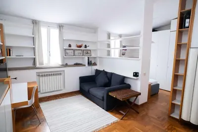 a living room with a blue couch and shelves at Tamara e Gerardina House in Trastevere in Rome