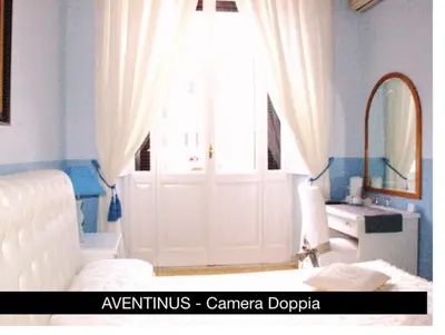 a bedroom with a white door and a mirror at Charme Holidays Colosseum in Rome