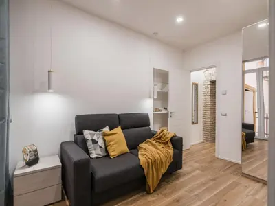 a living room with a black couch with yellow pillows at The Best Rent - Modern three-bedroom apartment a few steps from the Colosseum in Rome