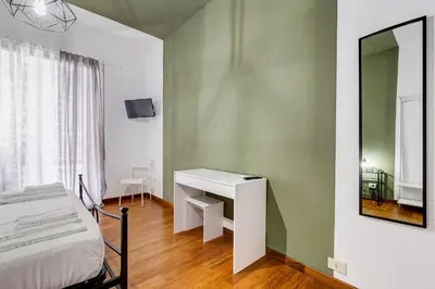 a bedroom with a bed and a desk and a mirror at BDC - Egeria 3-Bdr huge apartment in Rome