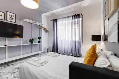 a white bedroom with a large bed and a couch at BDC - Egeria 3-Bdr huge apartment in Rome