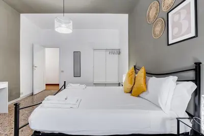 a bedroom with a large white bed with yellow pillows at BDC - Egeria 3-Bdr huge apartment in Rome
