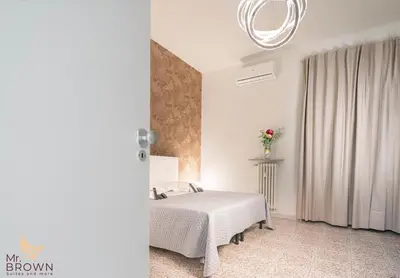 a white bedroom with a bed and a window at Mr. Brown - Marconi in Rome