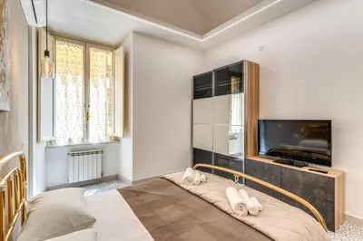 a bedroom with a large bed with a flat screen tv at Rhome Colosseum in Rome